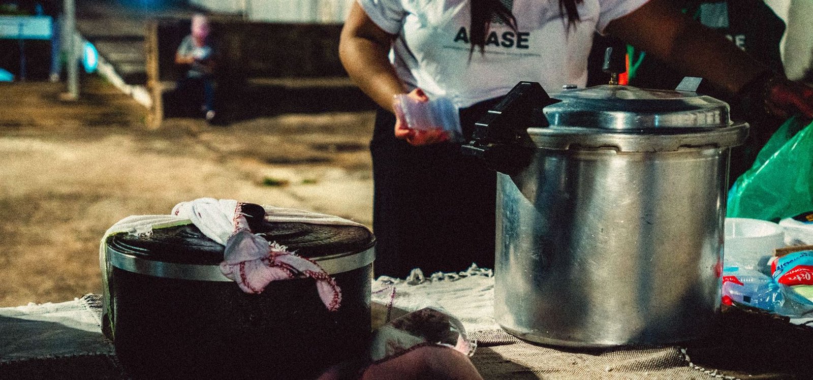 Panelas de sopa sobre a mesa durante a distribuição noturna da Mesa Acolhedora.